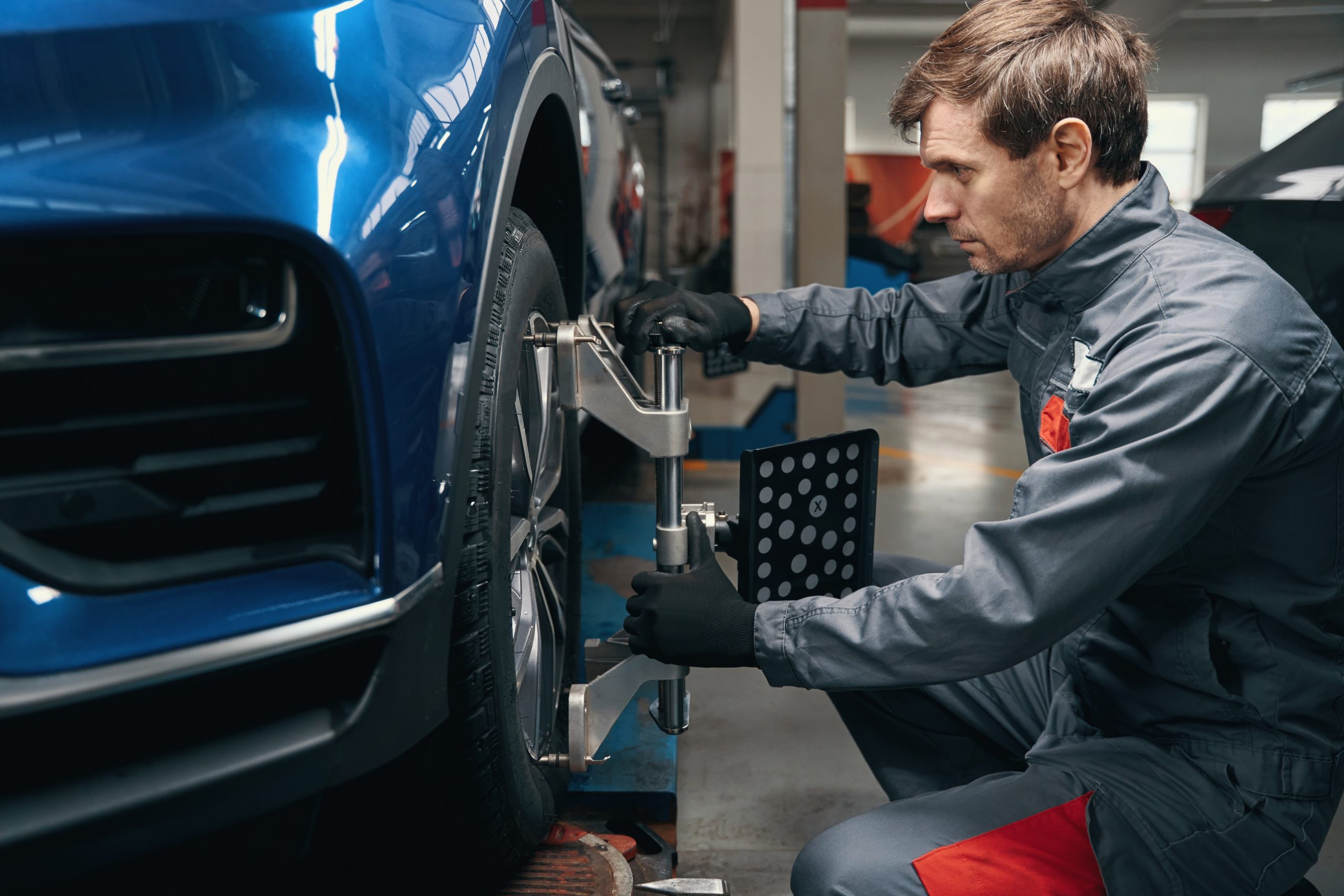 Technician performing wheel alignment service