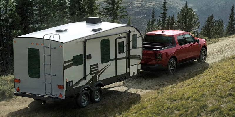 2026 Ford Maverick in Bloomington, MN towing a travel trailer along Highway 77, demonstrating 4,000 lb towing capacity.