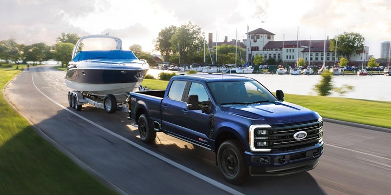 2026 Ford F-250 in Bloomington, MN towing a boat along I-35W, demonstrating heavy-duty towing capability.